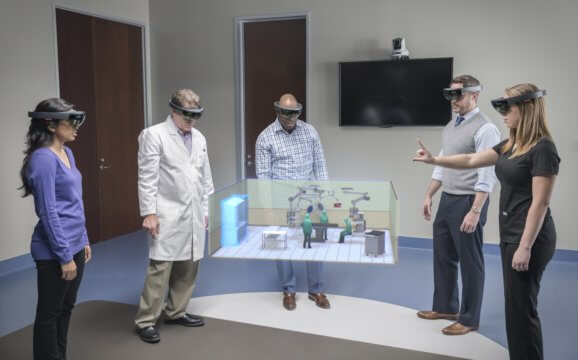 People using HoloLens to determine the best arrangement for an operating room.
